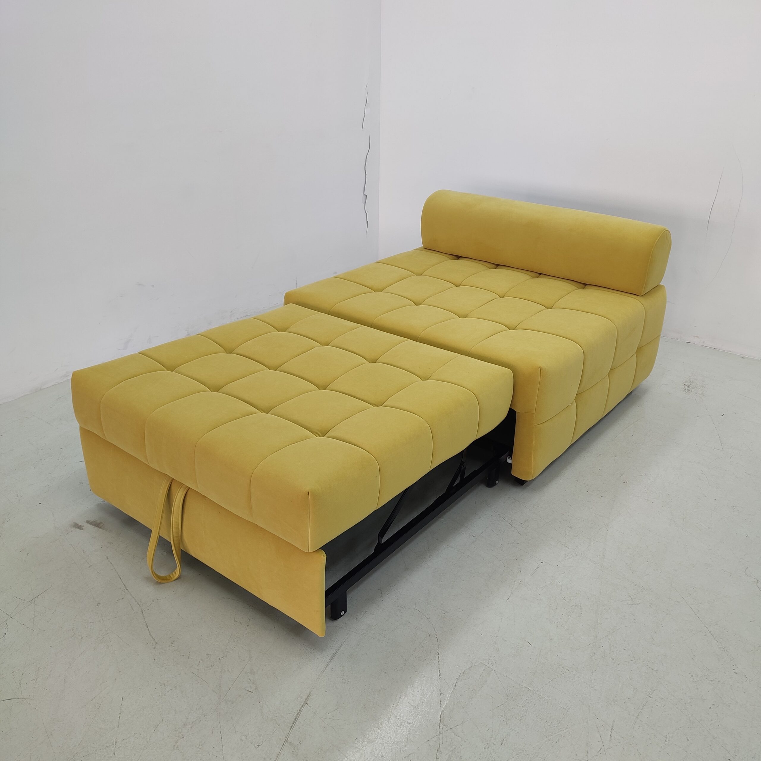 Compact yellow loveseat sofa bed extended into a single sleeping surface