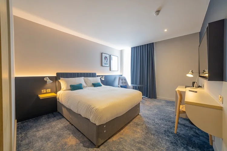 Hotel guest room furniture with upholstered bed and bedside tables