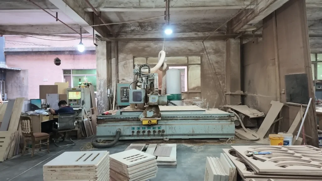 HUAXUAN Furniture workshop with CNC equipment and wood panels prepared for furniture production.