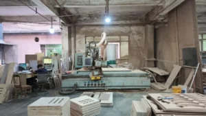 HUAXUAN Furniture workshop with CNC equipment and wood panels prepared for furniture production.