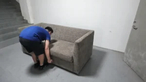 HUAXUAN Furniture worker checking a finished upholstered sofa before project delivery.