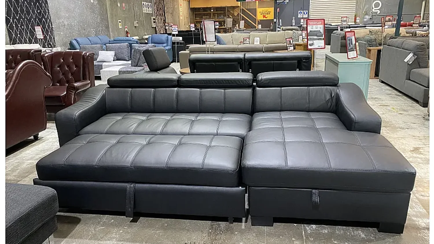 Black leather sofa bed in commercial showroom scene Black leather sofa bed in commercial showroom scene