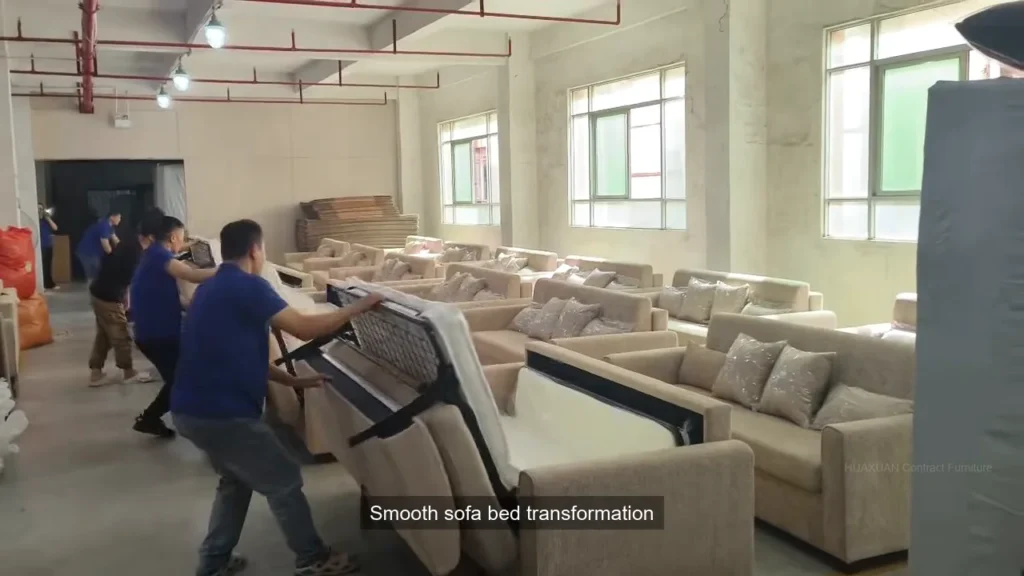 Factory technicians checking an upholstered sofa bed during production