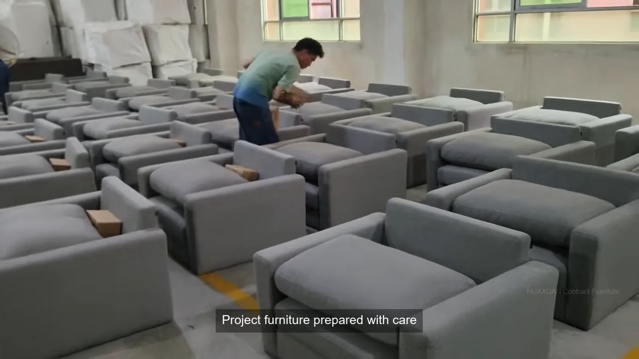 Worker inspecting a batch of finished upholstered sofas before packing