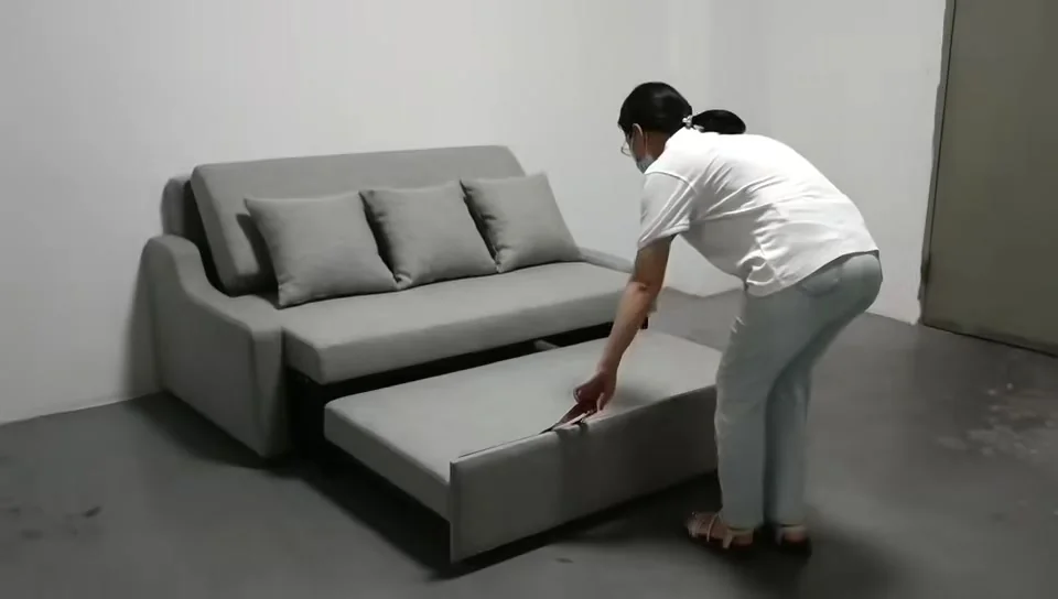 Compact pull-out sleeper sofa being extended from the front