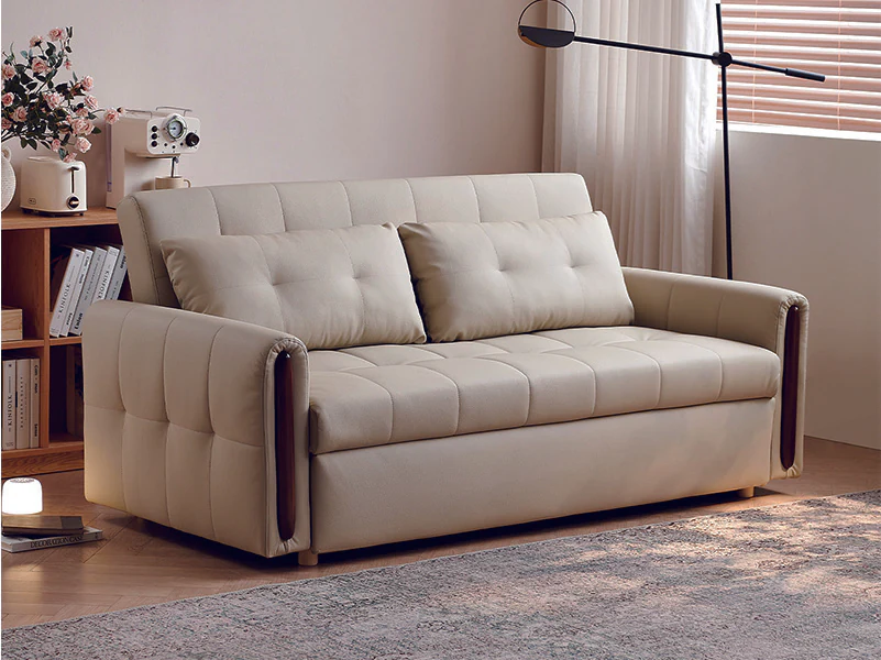 Ivory channel-tufted pull-out sofa bed with slim arms and painted-oak trim