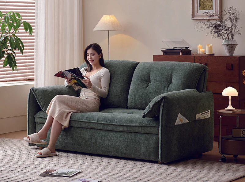 Forest-green pull-out sleeper sofa with loose pillow back and folded arm pads