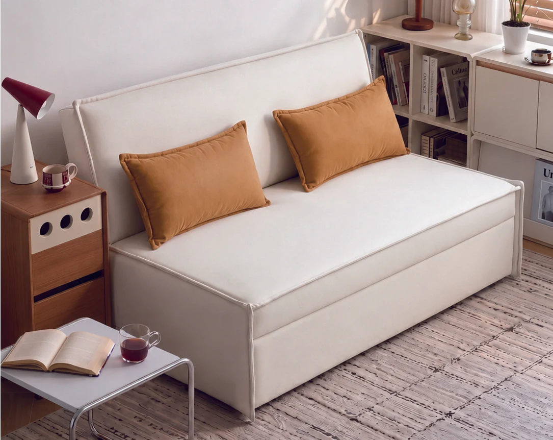 Minimal ivory armless pull-out sofa bed with two tan accent cushions