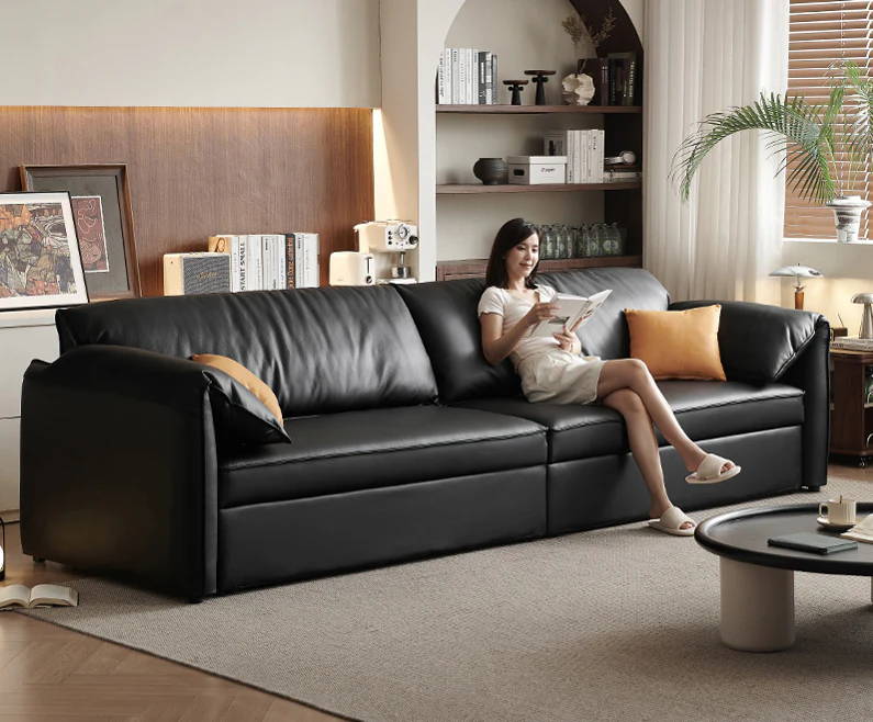 Wide black pull-out sleeper sofa with soft gathered pillow back cushions