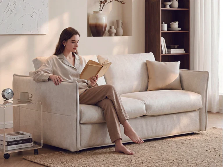 Light-sage slim-arm fold-out sofa bed with loose cushions in sofa mode