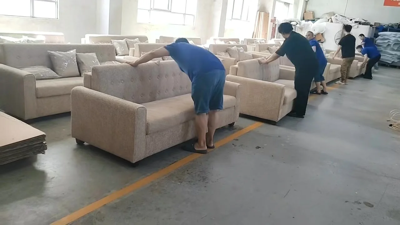 Workers resetting manual pull-out sofa beds after a function check
