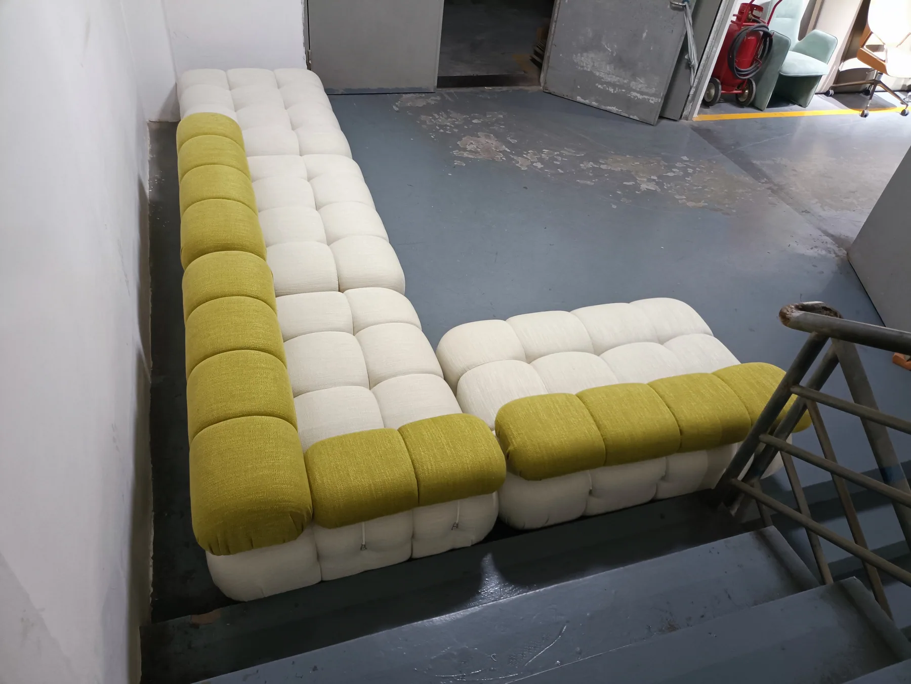 Large cream modular sectional arranged with a contrasting green back