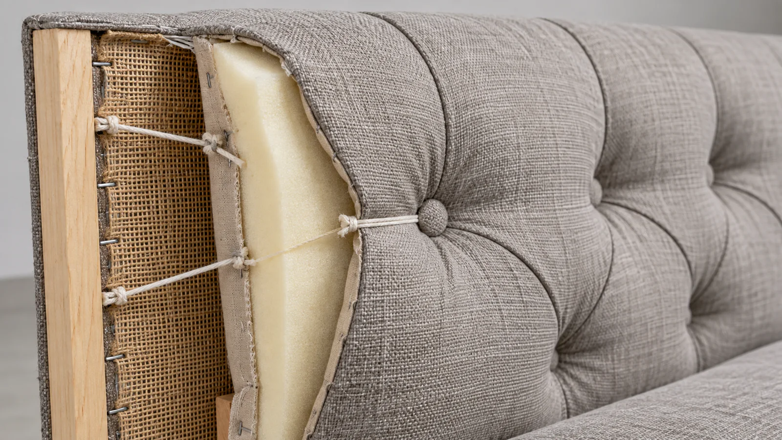 Cutaway detail of tufted sofa fabric foam backing and button fixing