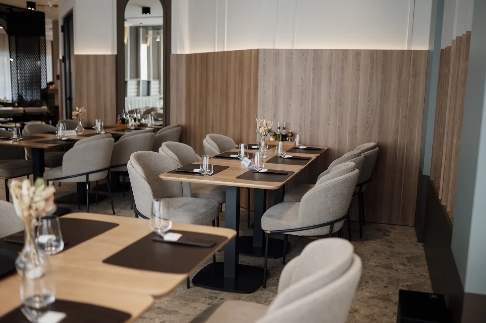 Soft upholstered dining chairs repeated at restaurant tables