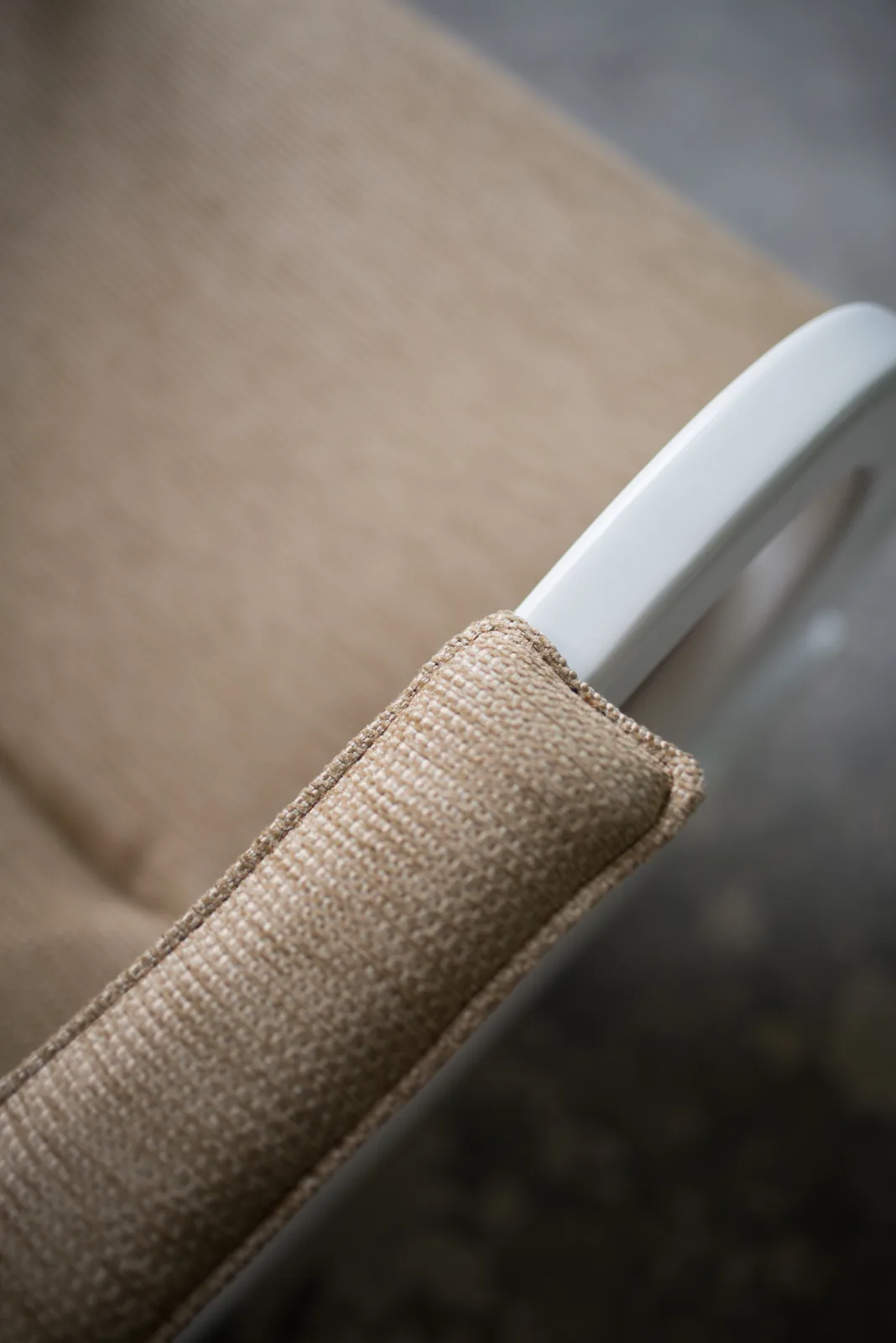 Close view of woven upholstery against a rounded chair arm