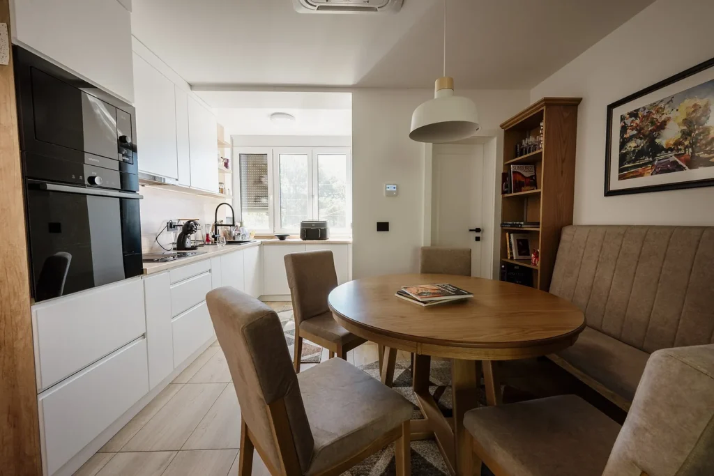 Beige upholstered dining chairs around a round wooden table