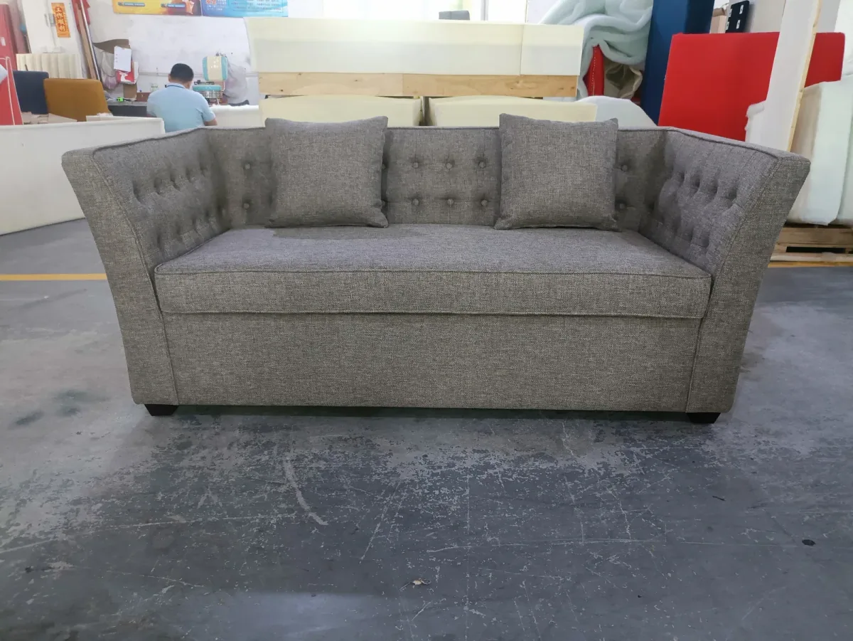 Grey pull-out sofa bed in closed seating mode with tufted back cushions