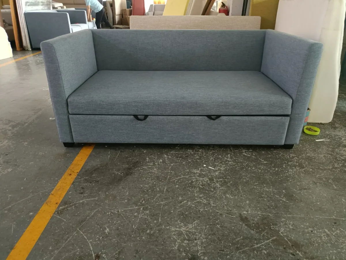 Grey compact sofa bed with its front pull-out section visible
