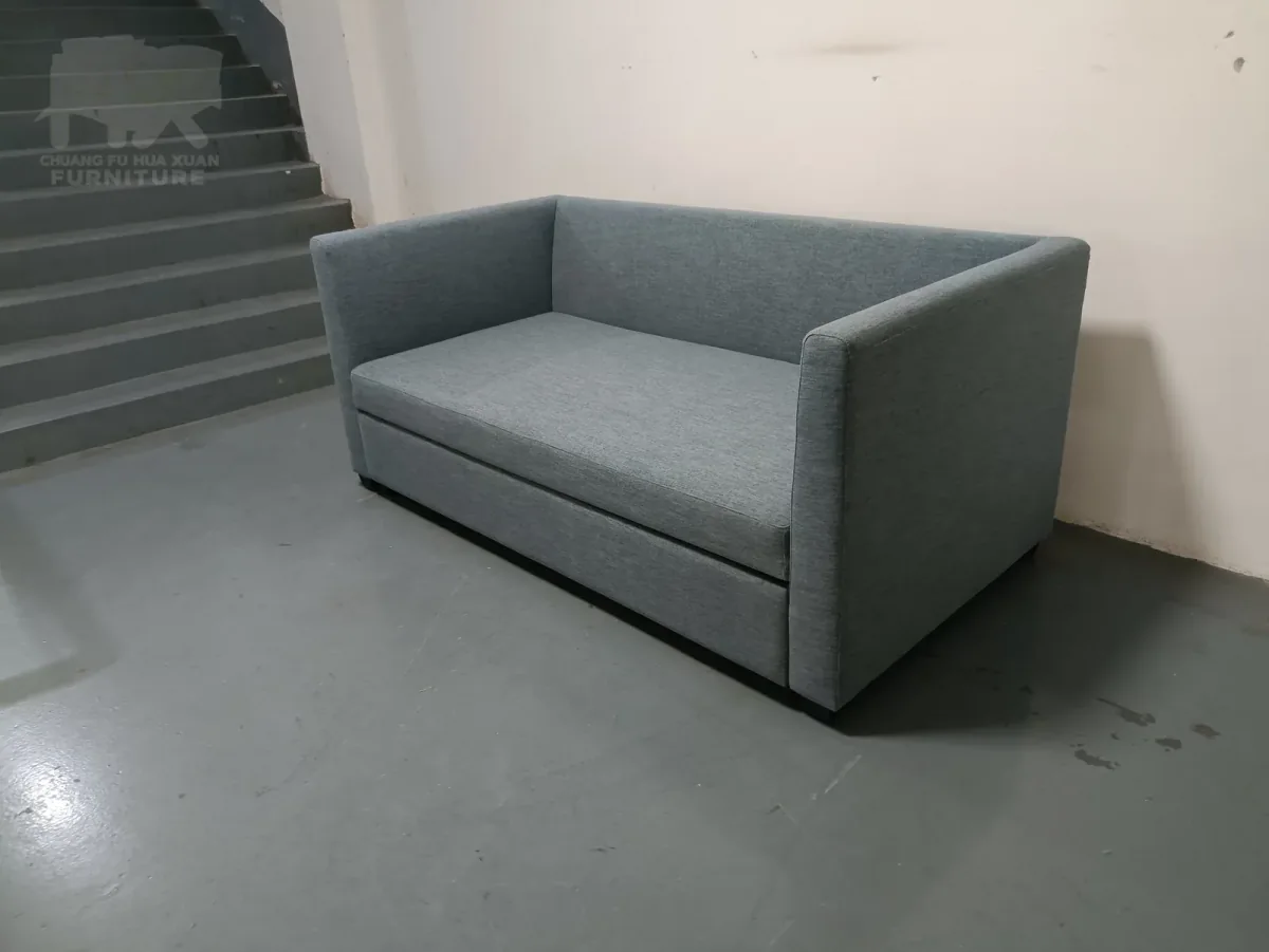 Close workshop view of a grey upholstered pull-out sofa bed in sofa mode