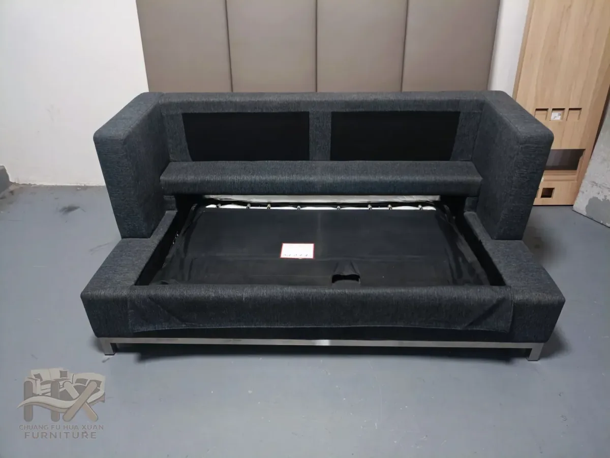 Dark grey sofa bed with its pull-out frame exposed for inspection